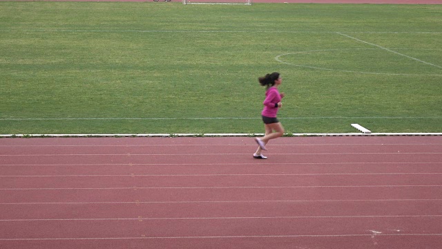 长头发成年女子在体育场奔跑的超高清录像视频下载