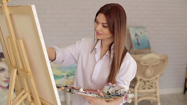 画室里一位才华横溢的女艺术家的肖像。视频下载