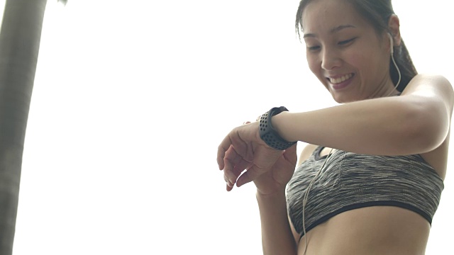 亚洲女人在智能手表上检查脉搏视频下载