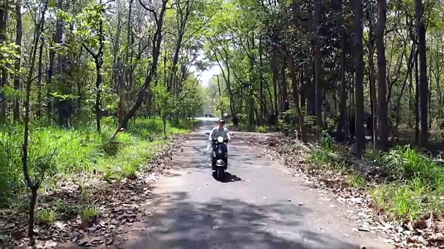 一名男子在乡村公路上开着摩托车。视频下载
