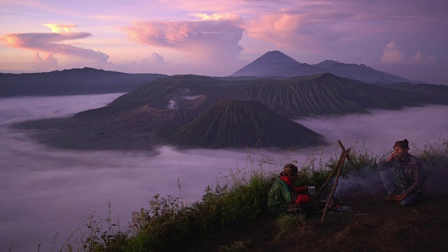 16-04-2018: Bromo Tengger Semeru国家公园，印度尼西亚:2当地人在篝火上，而日出与火山的背景视频素材