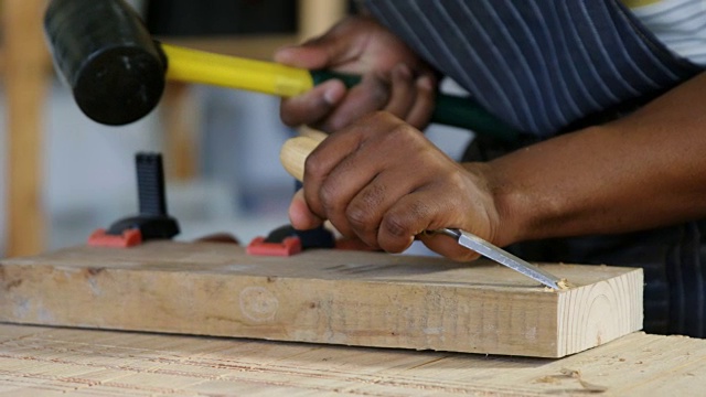 中间部分的木匠雕刻木材与锤子在桌子4k视频下载