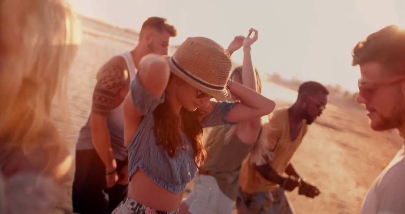 多民族的潮人朋友在夏日海滩聚会上跳舞日落视频素材