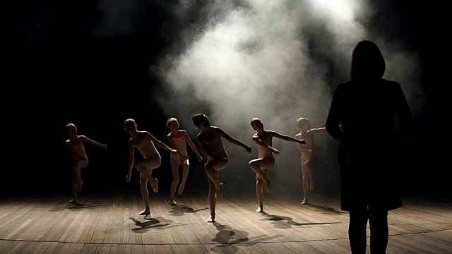 编舞在黑暗中教孩子们跳芭蕾。视频素材