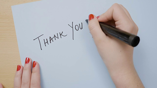 涂着红色指甲油的女人用黑色记号笔在蓝色纸上写感谢视频下载