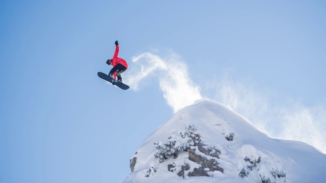 滑雪运动员从悬崖上跳下，落在刚下的雪上视频素材