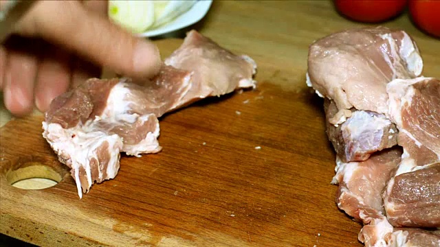 人的手用刀切肉。视频素材