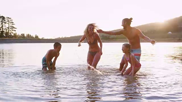 父母与孩子在湖中玩耍和戏水视频素材