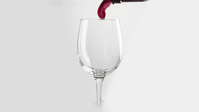 将红酒倒入白色背景的玻璃杯中。慢动作视频下载