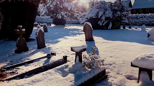 冬日的阳光照在白雪覆盖的墓碑上视频下载
