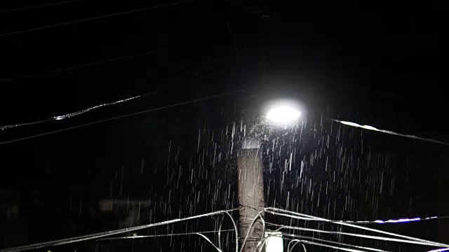 路灯在暴雨和雷电交加的夜晚亮起，声音包括在内视频素材