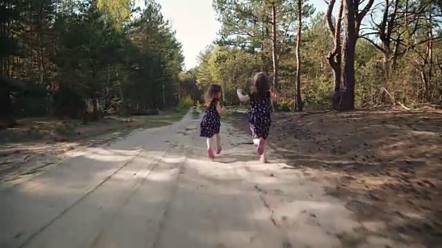 两个小女孩在夏日的森林里奔跑视频素材