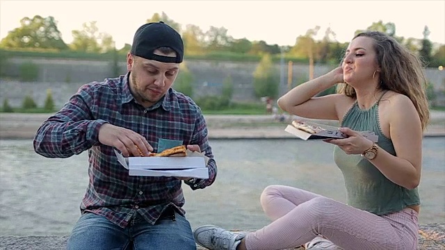 男女朋友在户外吃披萨，开怀大笑视频下载
