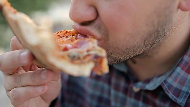 饥饿的人在户外吃披萨，特写视频下载