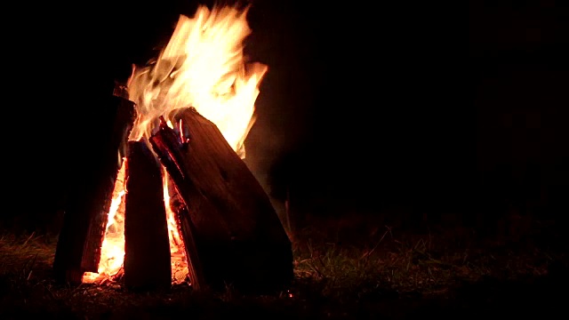 篝火在夜晚燃烧，篝火在漆黑的秋夜温暖视频素材