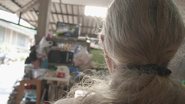 亚洲老人与长白发看电影在电视上。视频素材