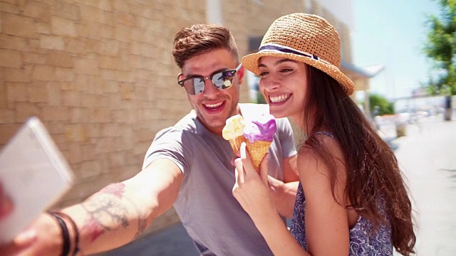 年轻的潮人情侣在夏天自拍和吃冰淇淋视频素材