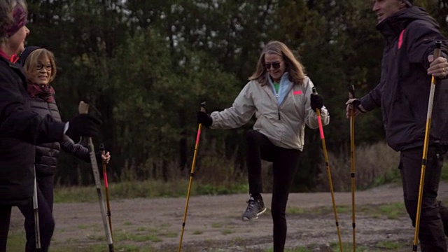 多莉拍摄了老朋友们在操场上拿着北欧手杖对着树锻炼的照片视频素材