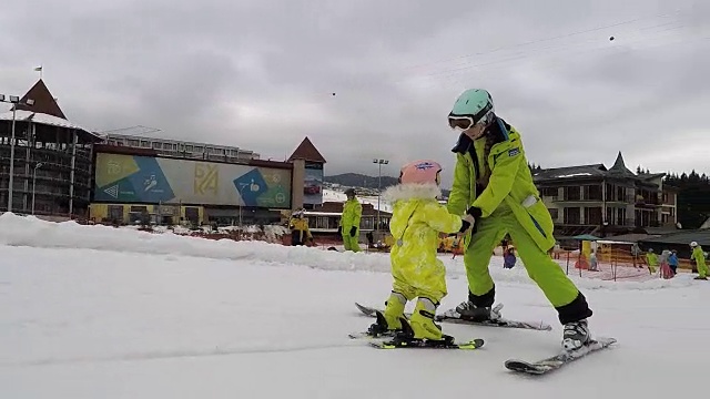 教练和婴儿在滑雪。视频素材