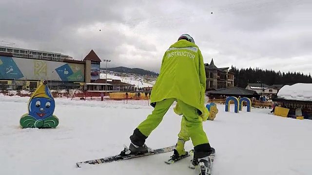 教练和婴儿在滑雪。视频素材