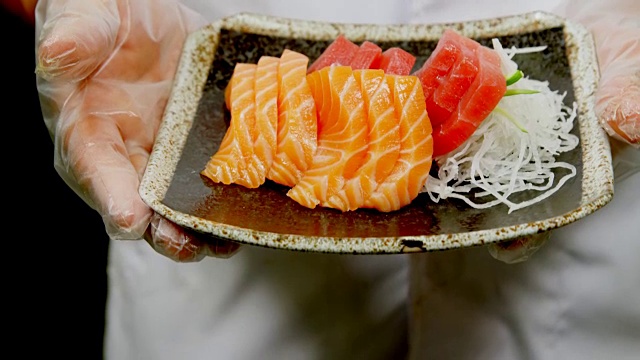男厨师拿着一盘寿司在4k厨房里视频素材
