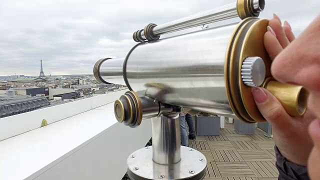 游客们在拉斐特画廊的露台上用投币式双目望远镜俯瞰巴黎的风景和埃菲尔铁塔视频下载