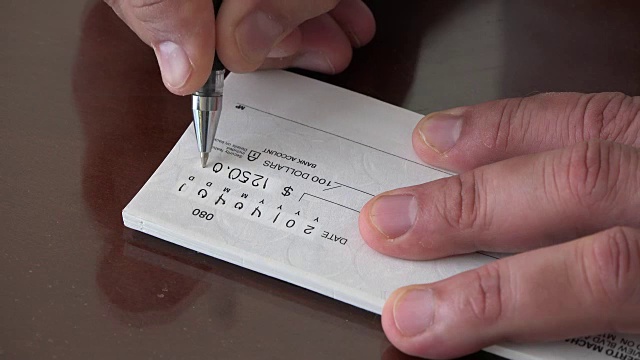 商业金融概念:男人写支票视频素材