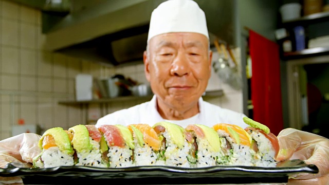 男厨师拿着寿司盘在厨房里视频素材