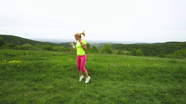 女运动员一边在大自然中跑步一边用秒表计时。视频素材