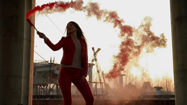 穿着红色服装的优雅女孩在古老建筑附近与红色烟雾跳舞视频素材