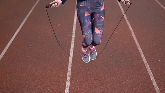 女子在运动跑道上跳绳视频下载