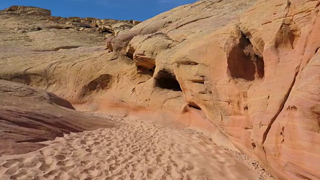 在平滑和波浪形的红岩峡谷之间干涸的河床上的运动镜头视频素材