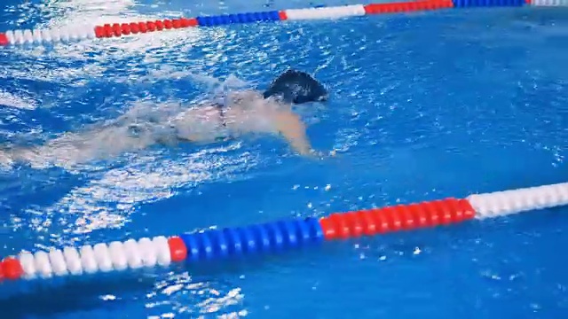 一名女子在游泳池泳道上游自由泳。4 k。视频下载