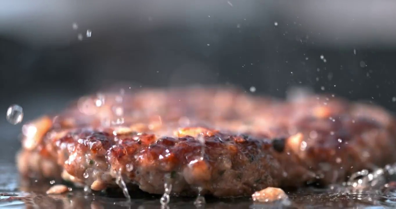 SLO MO:一个汉堡掉在电炉上的特写镜头视频下载