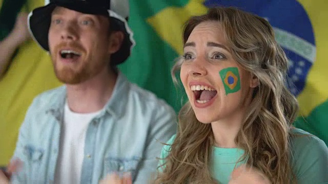 巴西球迷在电视上观看足球比赛，庆祝球队胜利视频素材