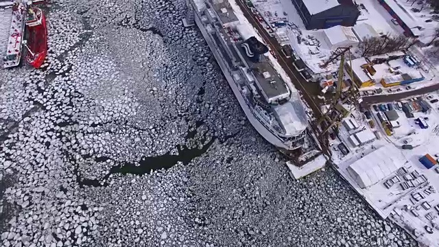 冬季有浮冰的冰河上造船厂的航拍图视频素材