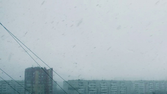 从窗口看，城市里有暴风雪。大雪和恶劣的冬季天气视频素材