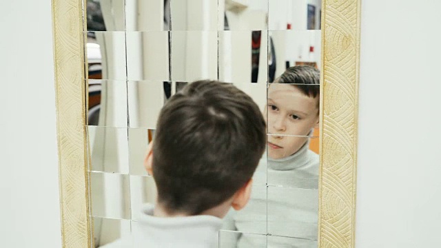 男孩在学校参观时在科学博物馆玩扭曲的镜子视频素材