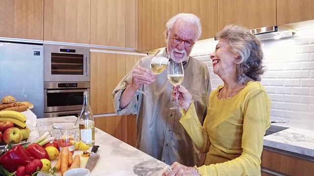 老夫妇在厨房里喝白葡萄酒视频素材