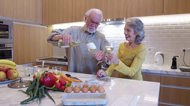 老夫妇在厨房里喝白葡萄酒视频素材