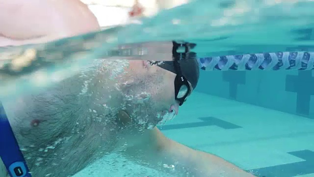 男子游泳的水下侧面镜头视频下载