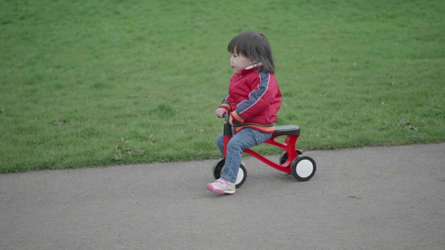 小女孩在户外公园玩自行车视频素材
