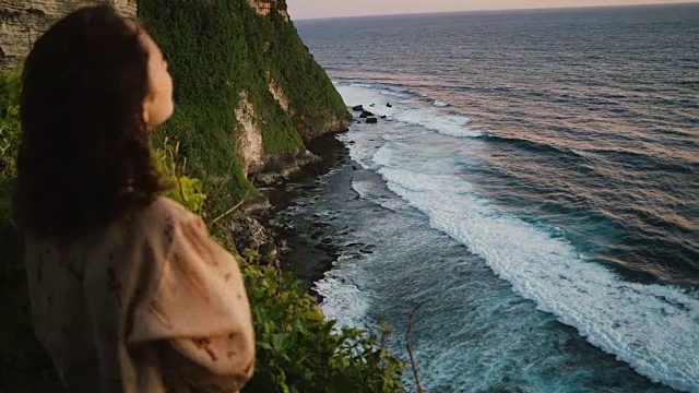 在巴厘岛的悬崖上看到大海的女人视频素材