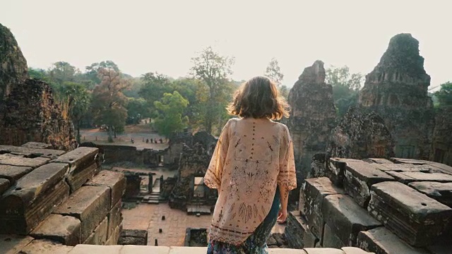 在柬埔寨吴哥窟里行走的女人视频素材