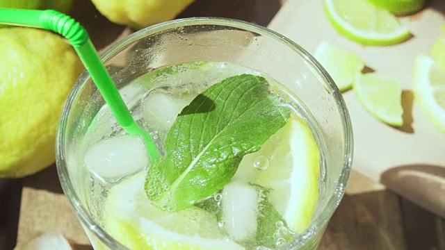 慢动作在一杯柠檬水中放入一根鸡尾酒吸管视频素材