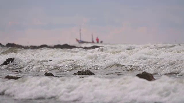 泰国热带海滩美丽的海浪和船击碎岩石海岸线的慢镜头视频素材