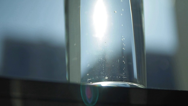 慢动作镜头的气泡起泡的矿泉水在玻璃杯。大特写镜头视频下载