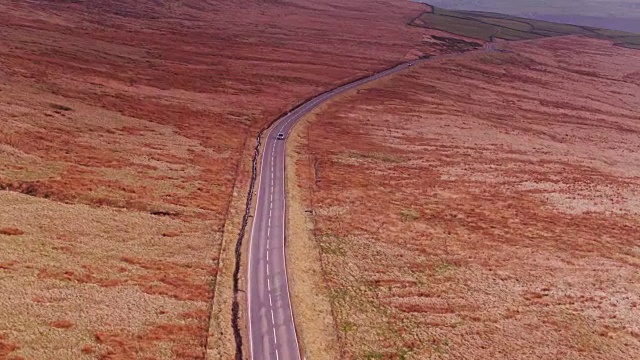 英国奥克森霍普和赫布登桥之间蜿蜒的乡村公路上的汽车-无人机拍摄视频素材