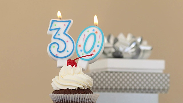 30支30支蜡烛在蛋糕粉背景上视频下载