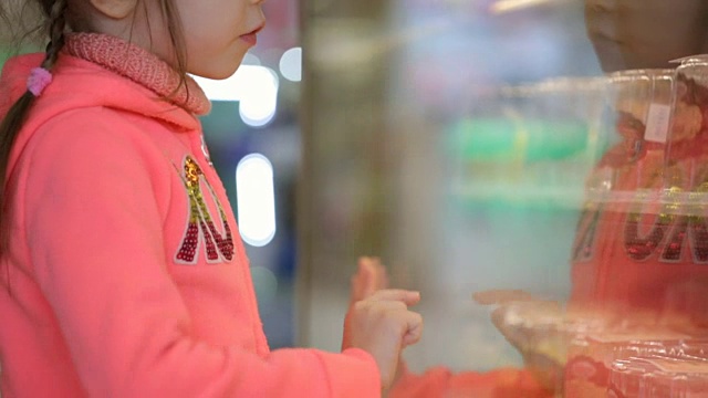小女孩在杂货店挑选蛋糕视频素材